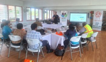Fiji e-waste training supported by TechCollect NZ and ANZRP, participants seated around tables with banners promoting recycling.