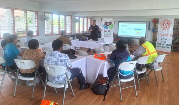 Fiji e-waste training supported by TechCollect NZ and ANZRP, participants seated around tables with banners promoting recycling.
