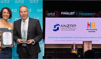 ANZRP team receiving AITD Best Learning Culture award on stage